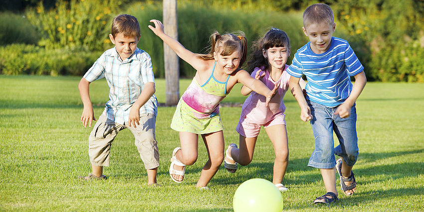 4 children chasing a ball