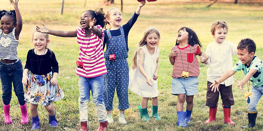 group of happy children in a grassy field