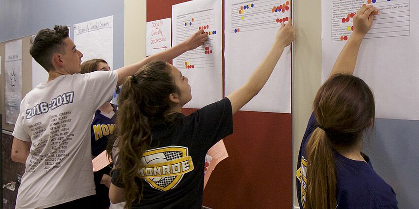 Students place stickers on posters