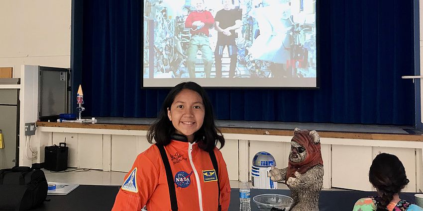 student wearing orange astronaut jumpsuit